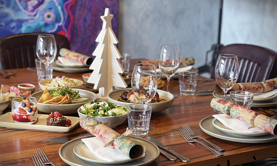 A festive table filled with share plates of food and wine glasses